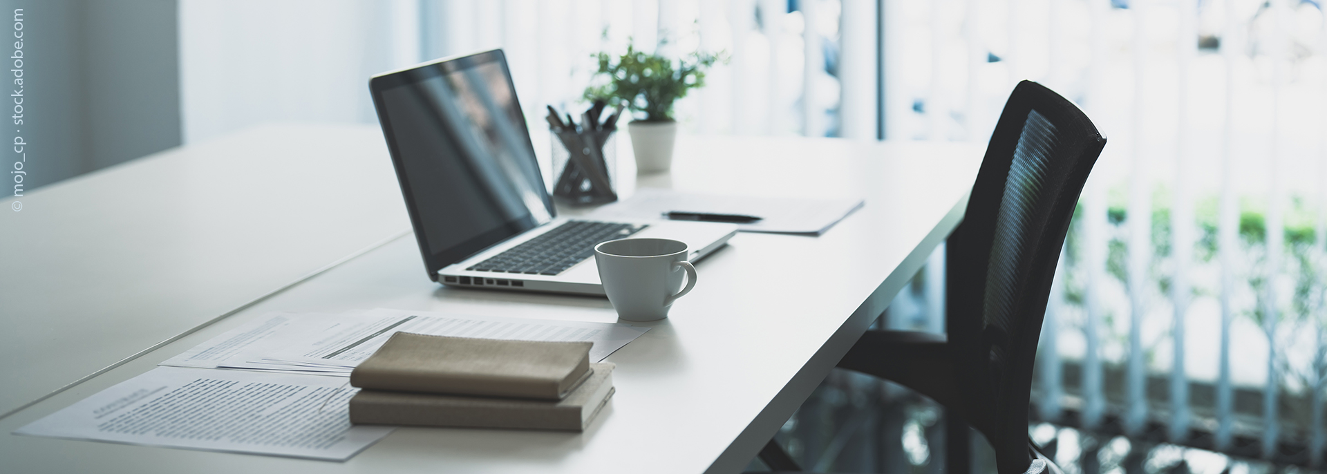 Tisch mit Laptop und Büchern 